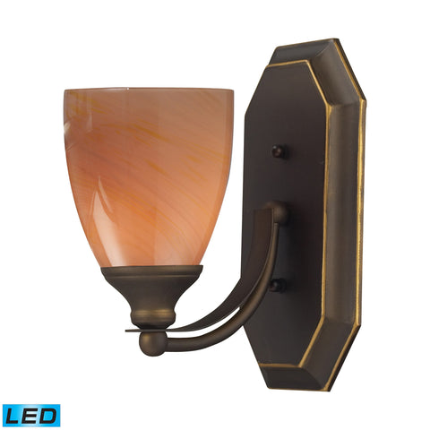 1 Light Vanity In Aged Bronze And Sandy Glass - LED Offering Up To 800 Lumens (60 Watt Equivalent) With Full Range Dimming. Includes An Easily Replaceable LED Bulb (120V).